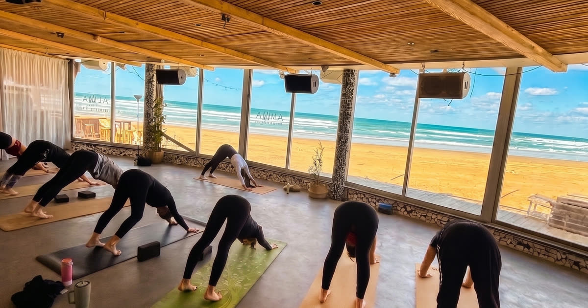 שיעור יוגה בעלמה וולנס קלאב מול הים בחוף פרישמן